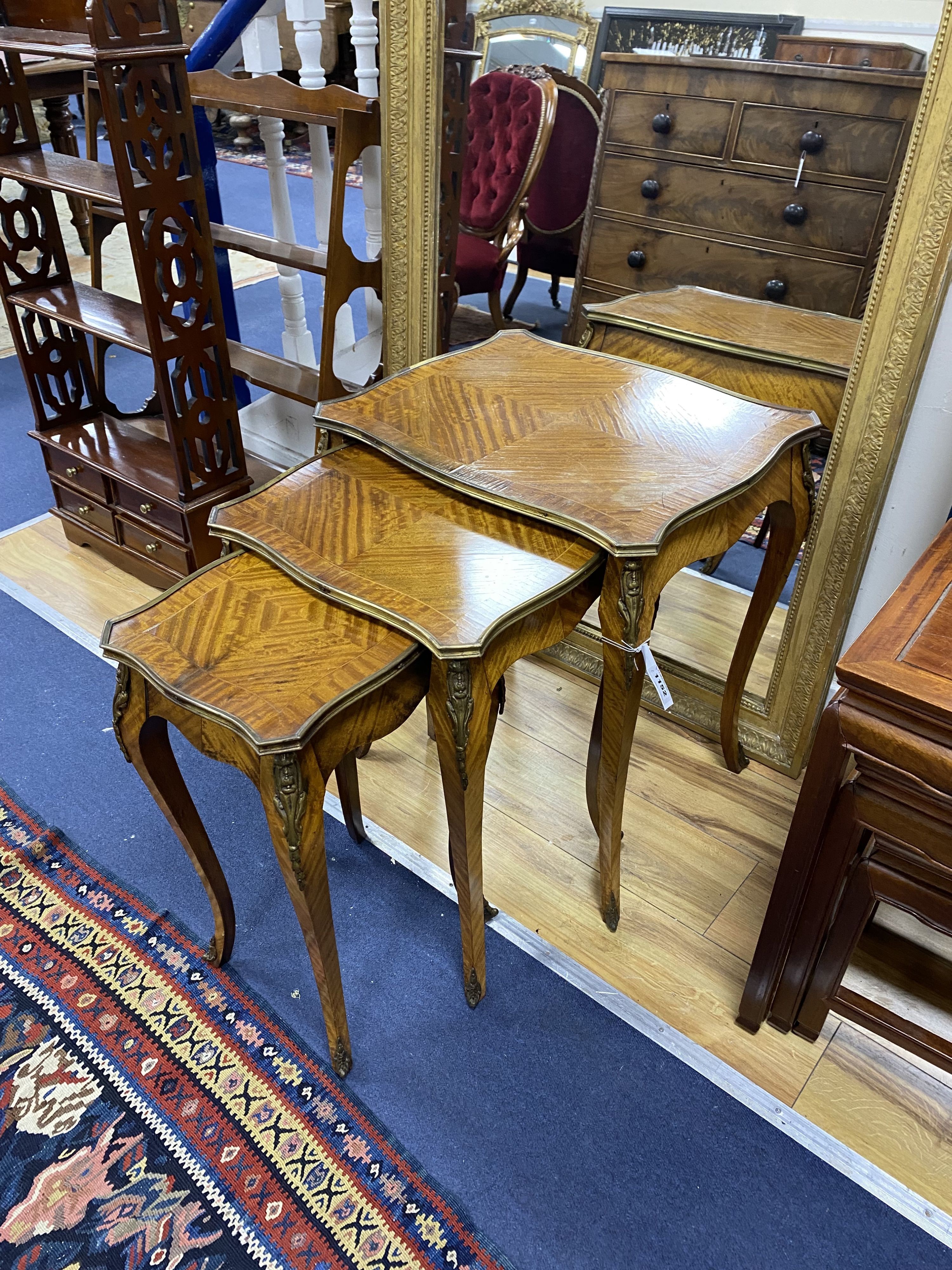 A nest of three Louis XV style ormolu mounted banded kingwood tables, with serpentine sides, on cabriole legs, width 51cm, depth 41cm, height 59cm